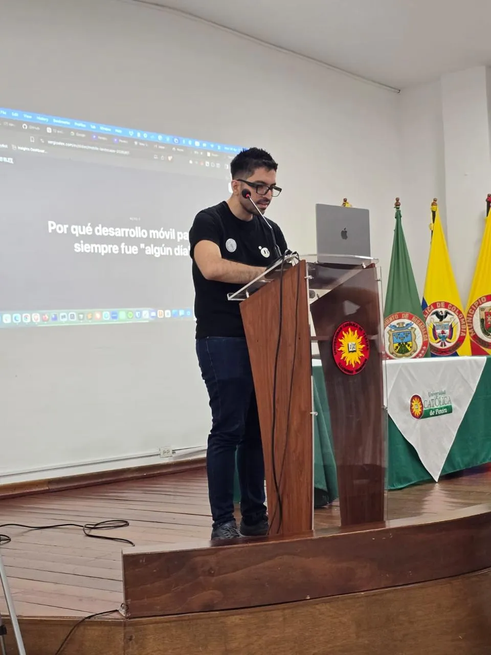 Sergio at the podium presenting, with the 'why mobile development was always someday' slide behind him
