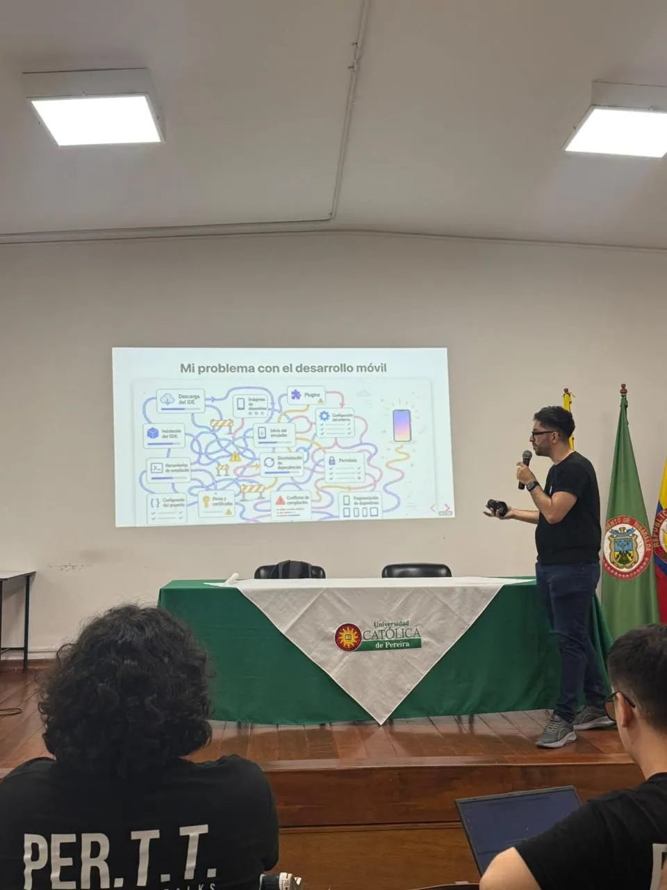 Sergio presenting the 'Mi problema con el desarrollo móvil' slide to the audience at Universidad Católica de Pereira